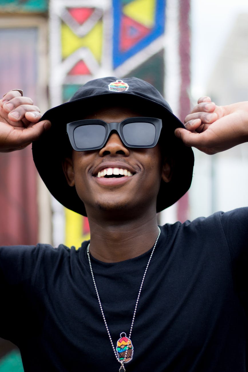 man in black crew neck shirt wearing black sunglasses and black cap