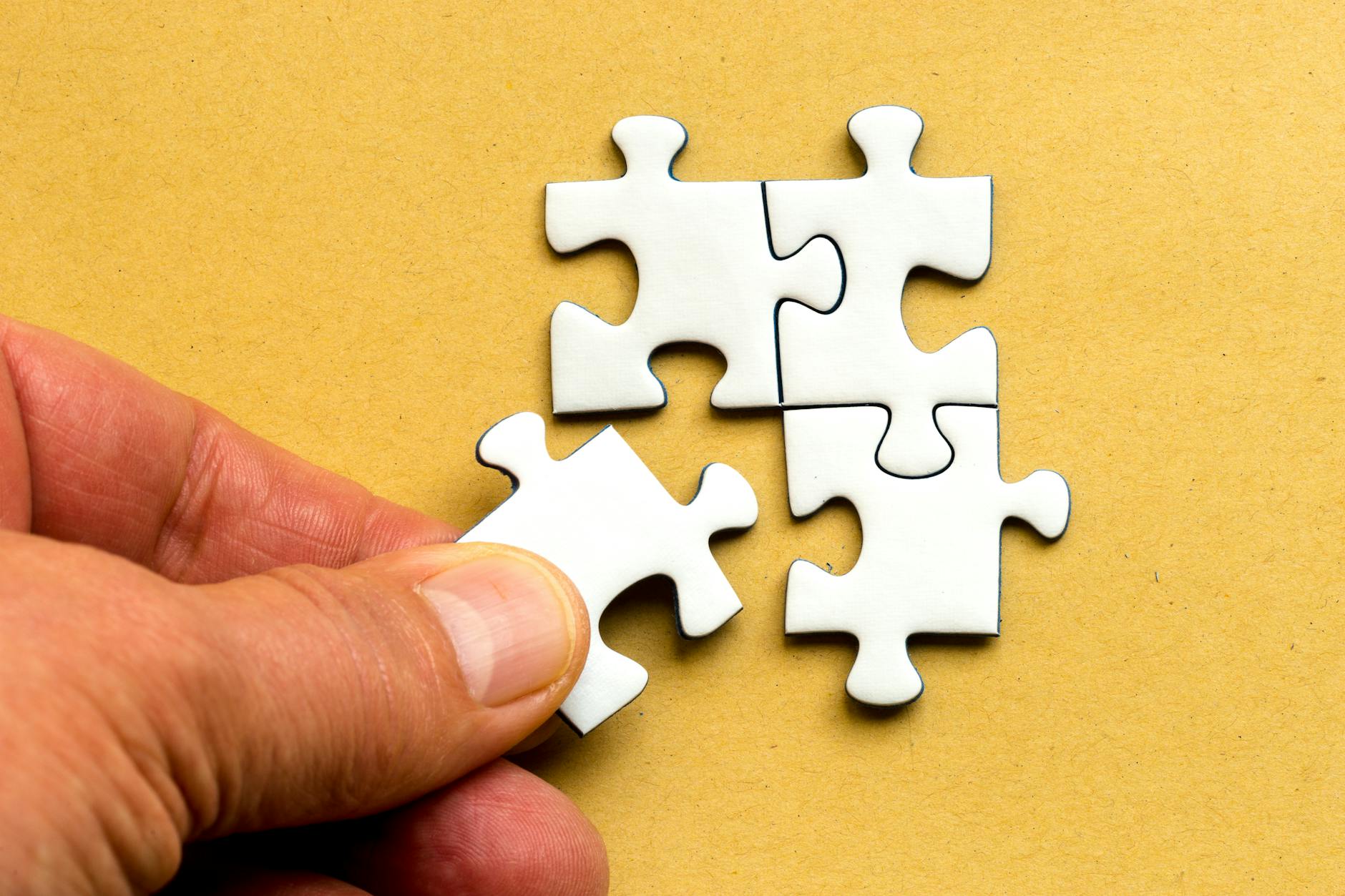 person holding white puzzle pieces