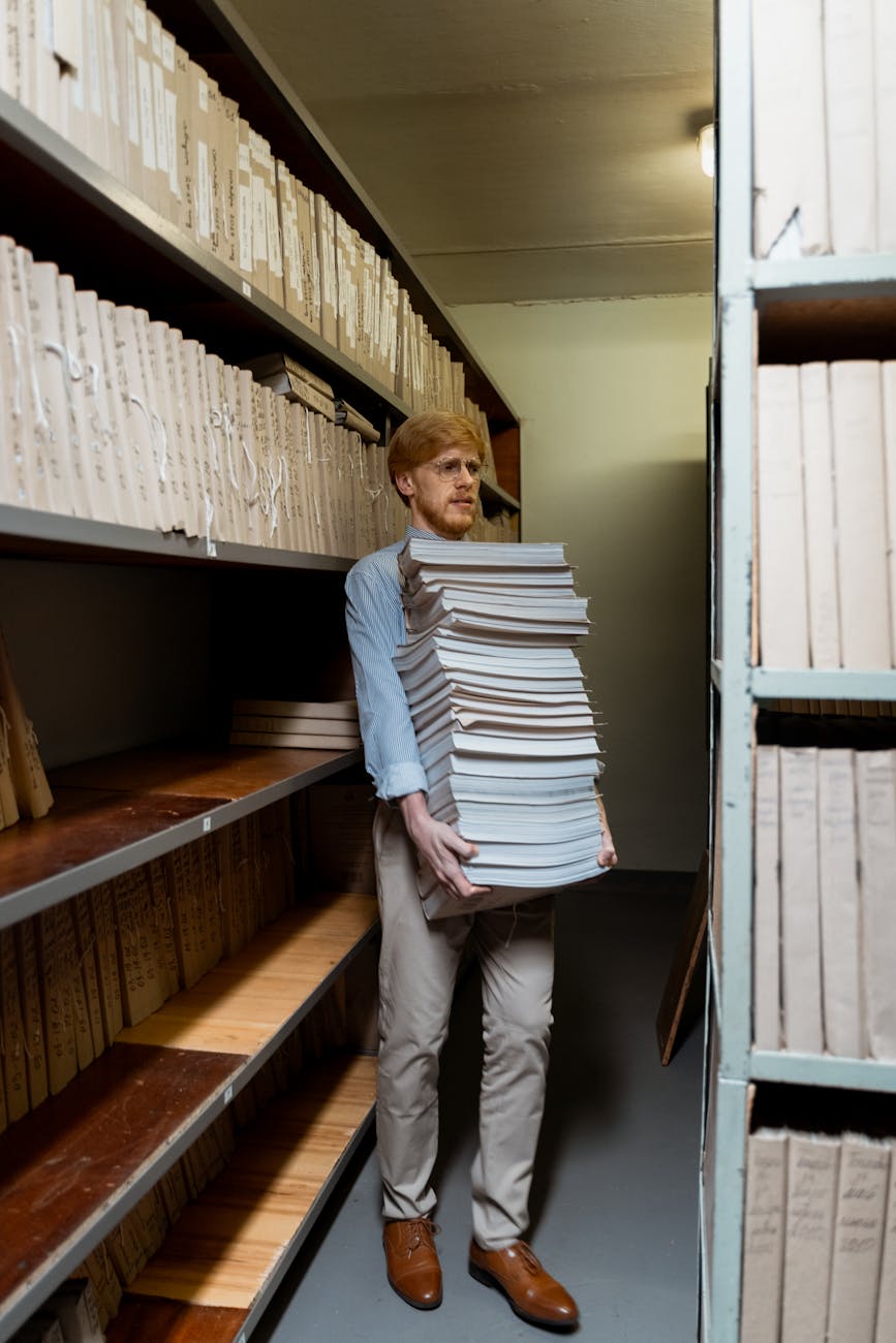 a man carrying pile of books
